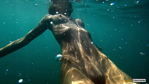 Nude model swims on a public beach in Russia.